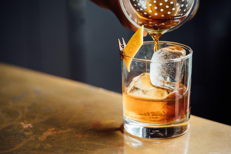 Bourbon cocktail being poured into a glass